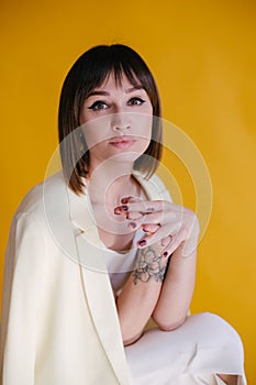 Woman in trendy clothes on yellow background.