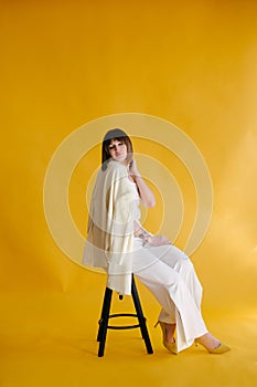 Woman in trendy clothes on yellow background.