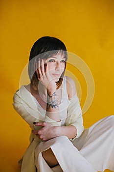 Woman in trendy clothes on yellow background.