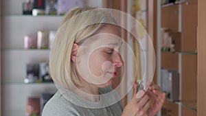 A woman tries the fragrance of perfume in a store.