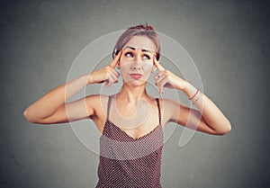 Woman tries to gather with thoughts, thinking about something, looking with doubt up