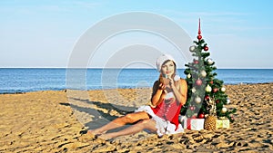 Woman on a tropical beach with a Christmas tree