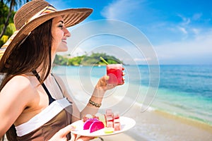 Woman at tropical beach eating fruit for breakfast