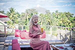 Woman with tropical mango juice outdoors, cafe. Bali island.