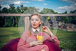 Woman with tropical mango juice outdoors, cafe. Bali island.