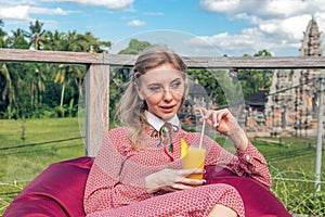 Woman with tropical mango juice outdoors, cafe. Bali island.