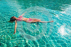 Una donna galleggiante sul profondo nuoto piscina 