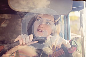 Woman truck driver in the car. Girl smiling at camera and holding the steering wheel.