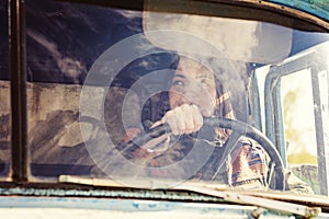 Woman truck driver in the car. Girl smiling at camera and holding the steering wheel.