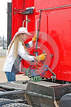 Woman Truck Driver Hanging Up The Air Lines.