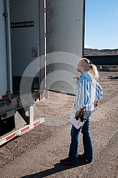 Woman truck driver inspecting the contents of her loaded trailer