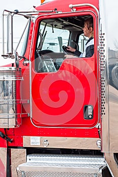 Woman Truck Driver looking out the windshield while driving a big rig