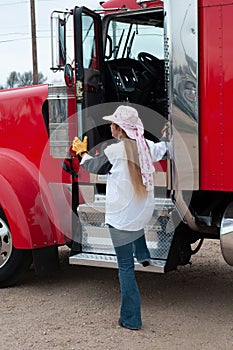 Woman trucxk driver getting into her big truck