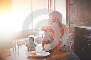 Woman on true kitchen sitting on a table with bread