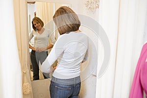 Woman trying on jeans and smiling