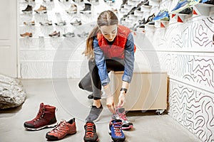 Woman trying shoes for hiking in the shop