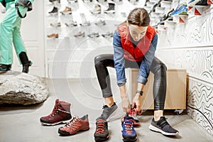 Woman trying shoes for hiking in the shop