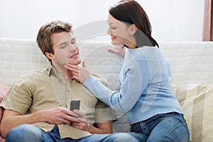 Woman trying to distract boyfriend from mobile