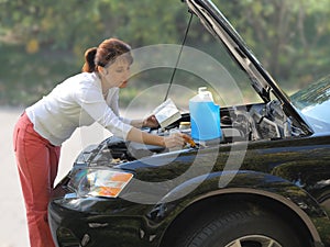 Woman trying to fix the car photo