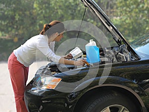 Woman trying to fix the car