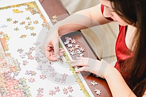 Woman trying to match pieces of a Jigsaw Puzzle Game.