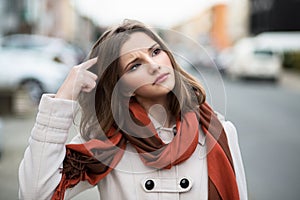 Woman trying to remember looking at up.