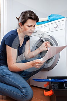 Woman trying to repair washing machine