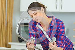 woman trying to repair water tap