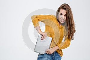 Woman trying to shove tablet computer in her pocket photo