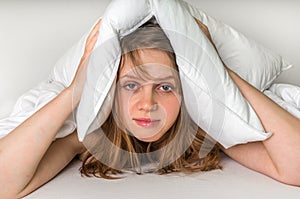 Woman trying to sleep, she covering ears with pillow