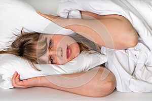 Woman trying to sleep, she covering ears with pillow