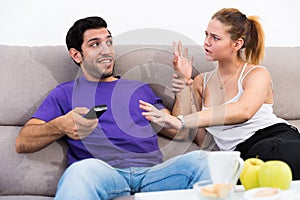 Woman trying to take away TV remote from boyfriend