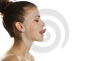 Woman trying to touch the nose with her tougue