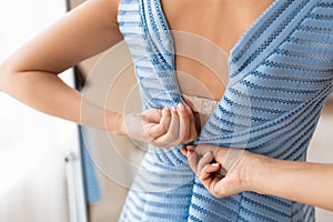 Woman Trying To Zip Up Dress Standing At Home, Cropped