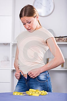 Woman trying to zip up jeans