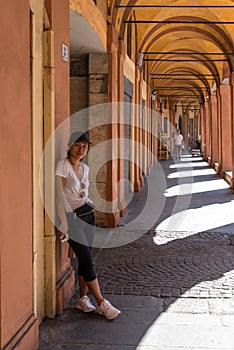 Woman in tshirt ,sneakers and black hat with sunglasses standing by The Portacoes Promanade