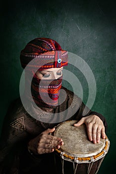 Woman in turban playing drum