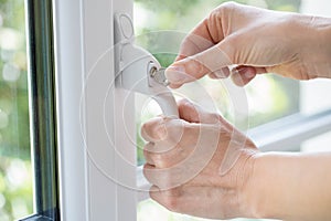 Close Up Of Woman Turning Key In Window Lock