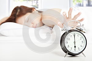 Woman turning off the alarm clock