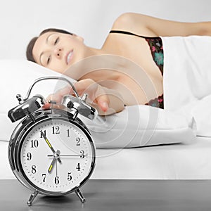 Woman turning off her alarm clock