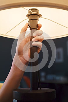 Woman turning on a table lamp