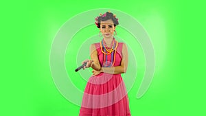 Woman with TV remote in her hand, switching on TV bored. Green screen