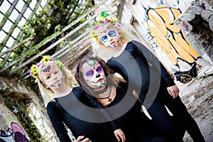 Woman and twin girls with sugar skull makeup