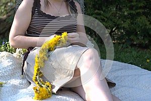 Woman twining a traditional wreath of dandelion