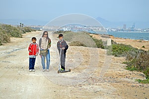 Woman And Two Boys With A Scooter.