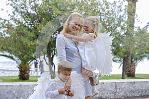 Woman with two little children walks in the park