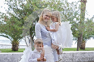 Woman with two little children walks in the park