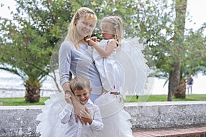 Woman with two little children walks in the park