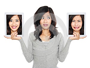 Woman with two tablet computer screen. one with smiling face and