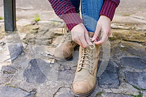 Woman is tying her boot